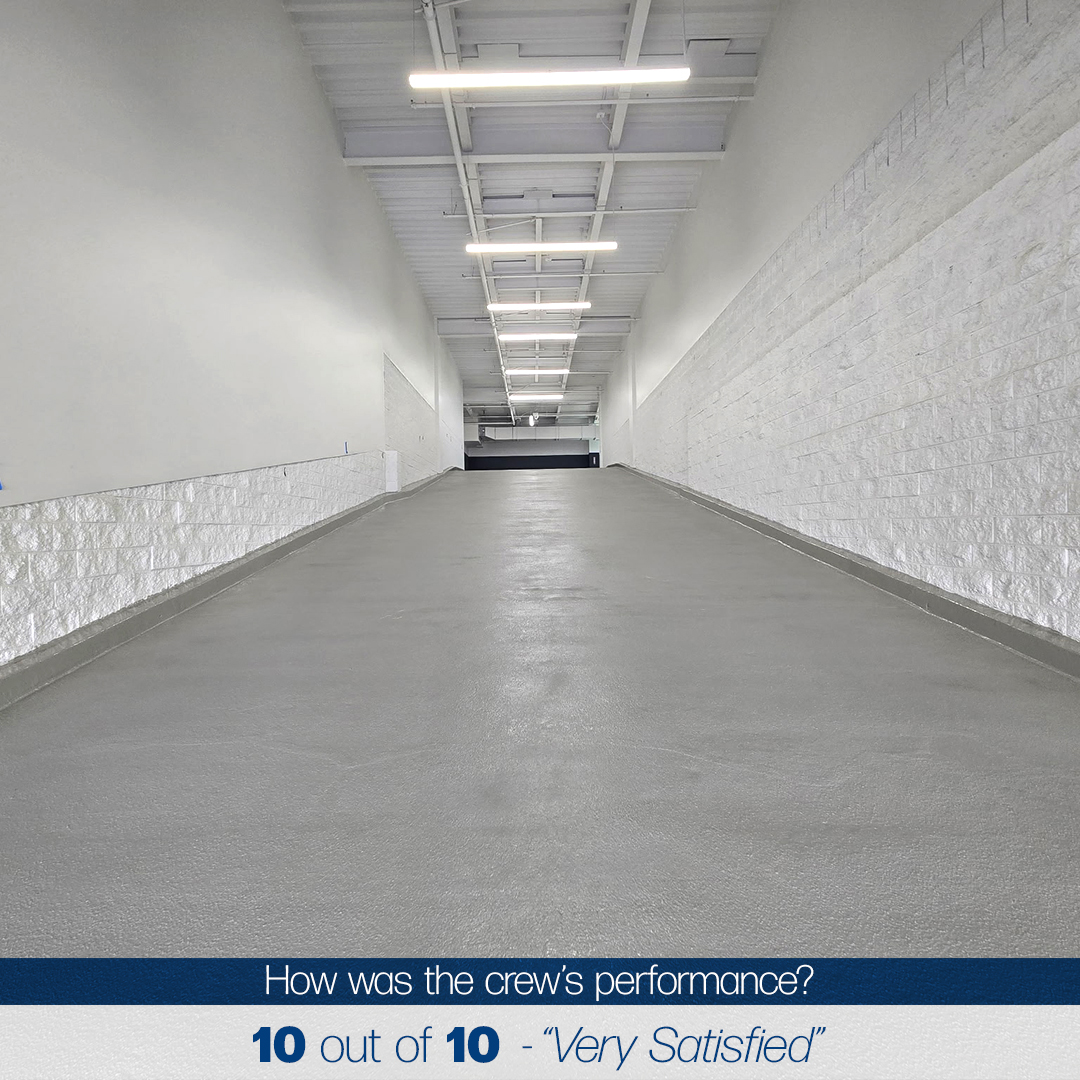 A clean, freshly finished concrete floor in a well-lit, empty warehouse hallway with a caption rating the crew's performance 10 out of 10 and stating "Very Satisfied.