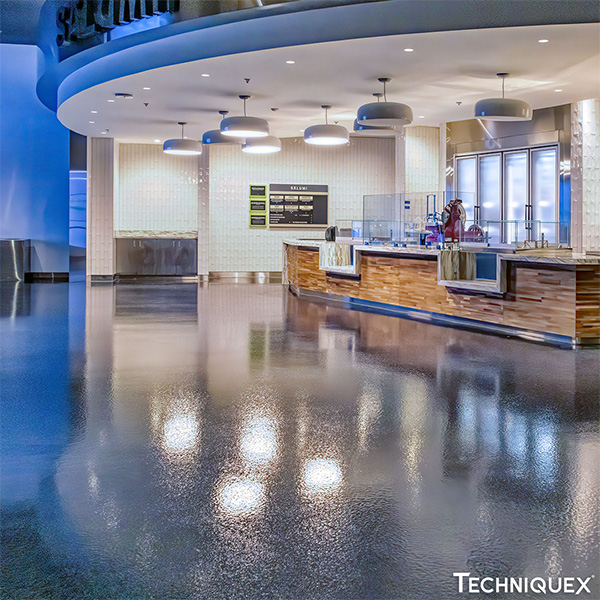 Modern cafeteria with a curved serving counter, overhead lighting, menu boards on the wall, and a glossy polished floor.