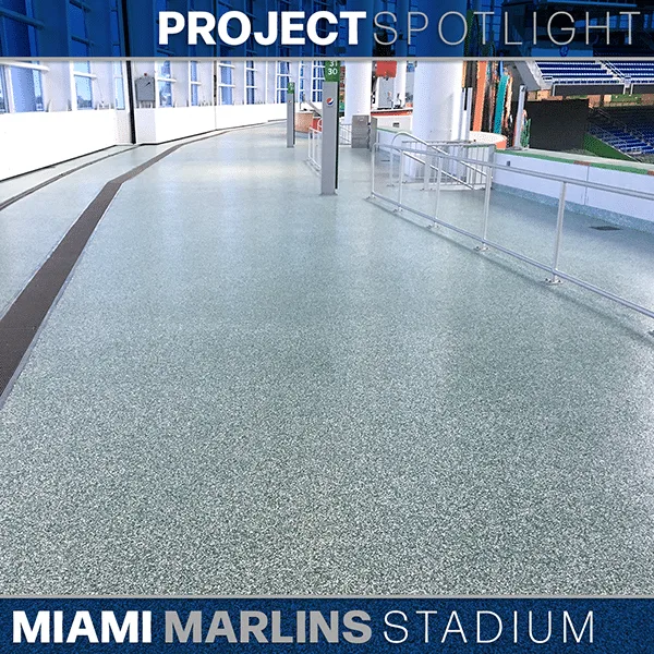 Wide interior walkway at Miami Marlins Stadium featuring polished flooring, railing, and large windows under the "Project Spotlight" banner.
