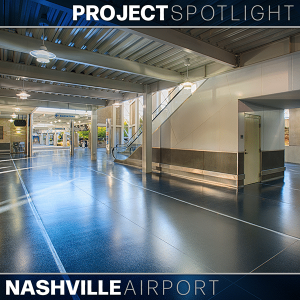 Interior view of Nashville Airport showing shiny floors, an escalator, overhead lighting, and signage for elevators and other facilities.