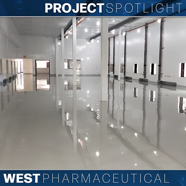 Large, empty, clean industrial facility with glossy floors, white walls, and ceiling lights. Text overlay reads “Project Spotlight: West Pharmaceutical.”.