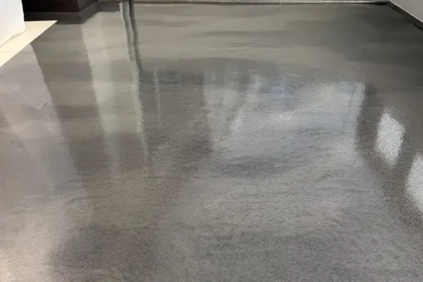 A smooth, reflective grey epoxy floor in a room with white walls.